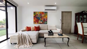 Una sala de estar moderna con un sofá modular, una mesa de centro y un cuadro abstracto de colores.