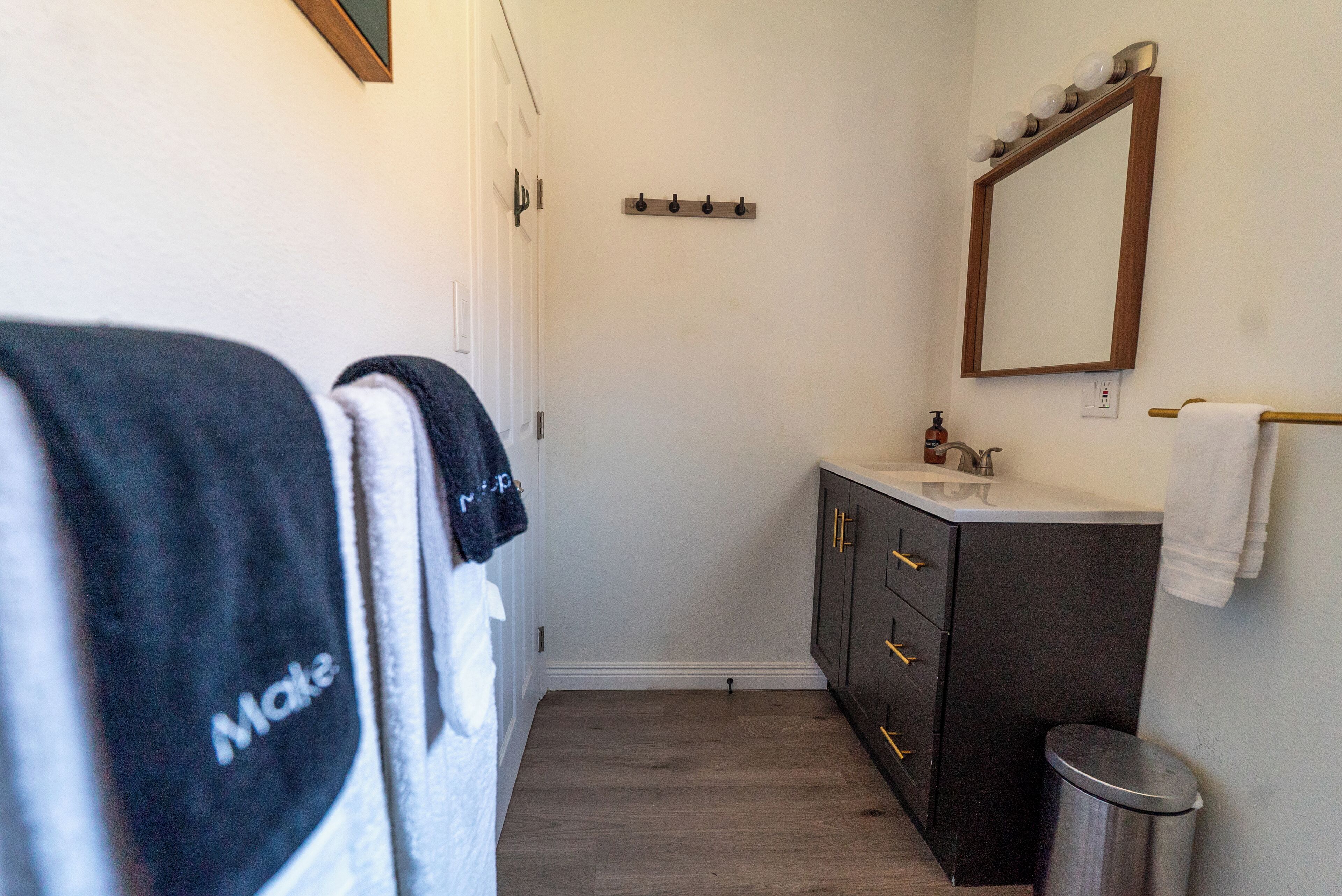 A bathroom with a sink, mirror, and towel rack.