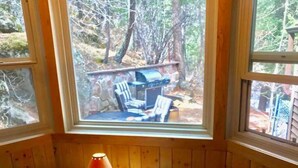 A cabin interior with a window overlooking a deck area. - November Riverfront Retreat Near Estes Park and RMNP (Drake)
