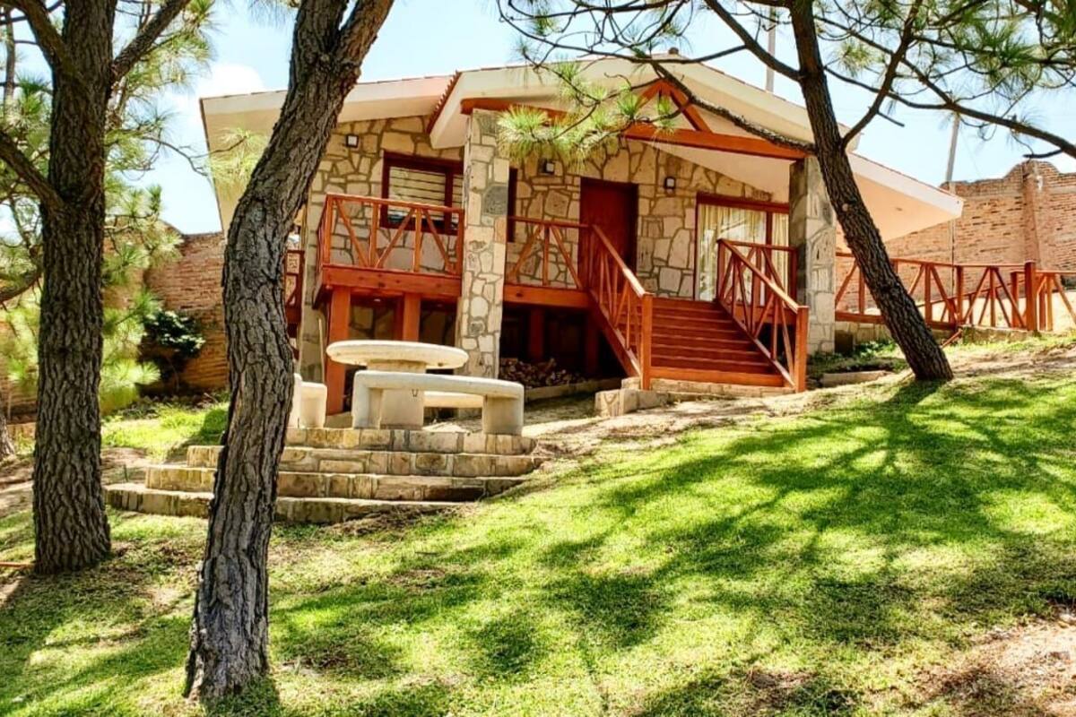 A stone building with a wooden staircase leading to a covered porch.