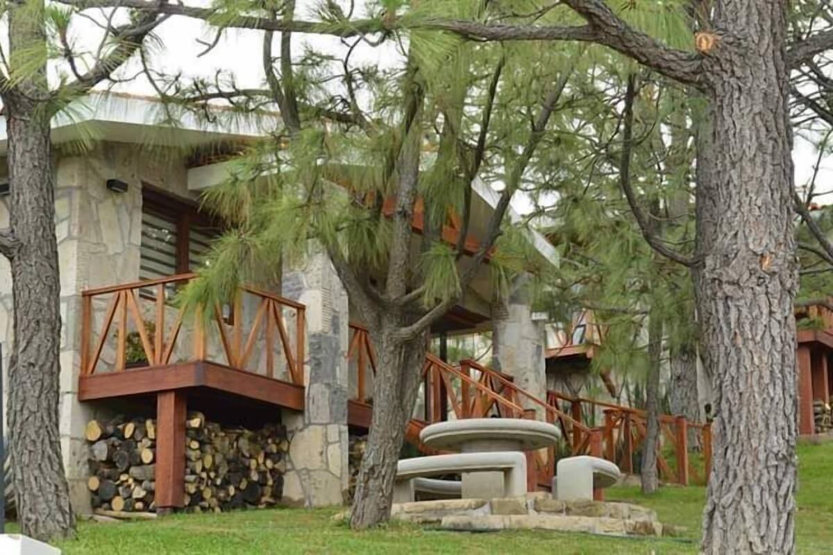 A resort with a stone building, wooden deck, and a stone fireplace.
