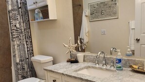 Un baño con inodoro, lavamanos, tocador y ducha.