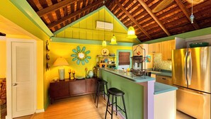 A kitchen with a wooden ceiling, a green island, and a stainless steel refrigerator. - Beautiful Old Town 2 bedroom Cottage on a Private Lane (Key West)