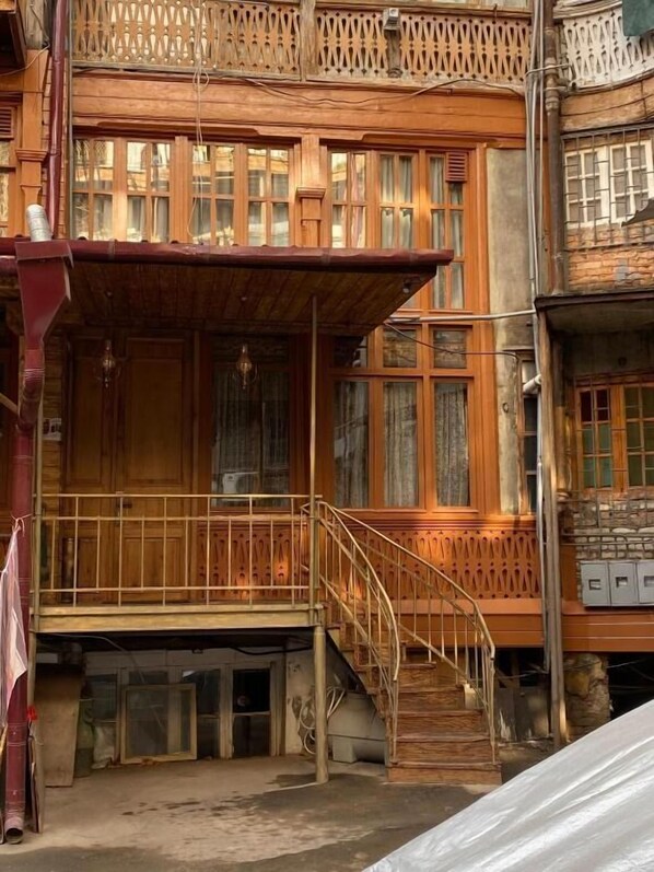 A wooden building with a balcony, wooden railings, and a staircase leading to an upper level. - Boutique Fantasy (Tbilisi)