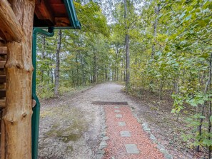 A forest path with a wooden structure on the left.