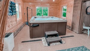 A wooden cabin with a hot tub, two steps, and a dartboard. - Ash Ridge Lodge in Hocking Hills (Laurelville)