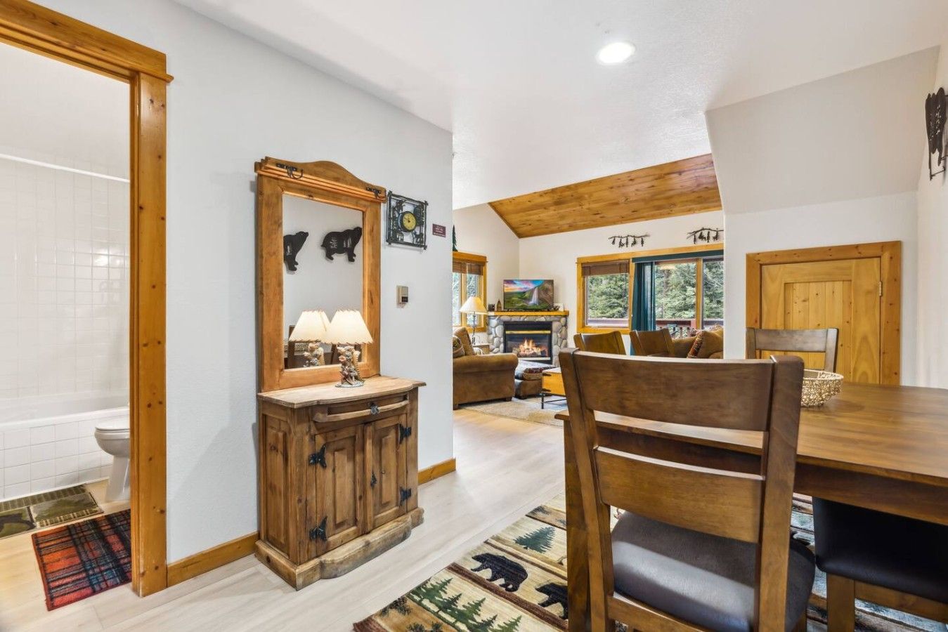 A wooden dining table with chairs, a fireplace, and a living area with a couch and television.