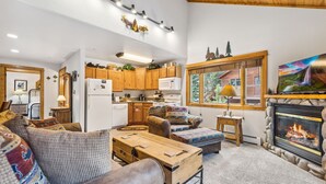 A cozy living room with a fireplace, wooden furniture, and a television. - Fall River Hideaway • Peaceful • Near RMNP (Estes Park)