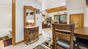 A cozy room with a wooden dining table, a fireplace, and a large mirror. - Fall River Hideaway • Peaceful • Near RMNP (Estes Park)