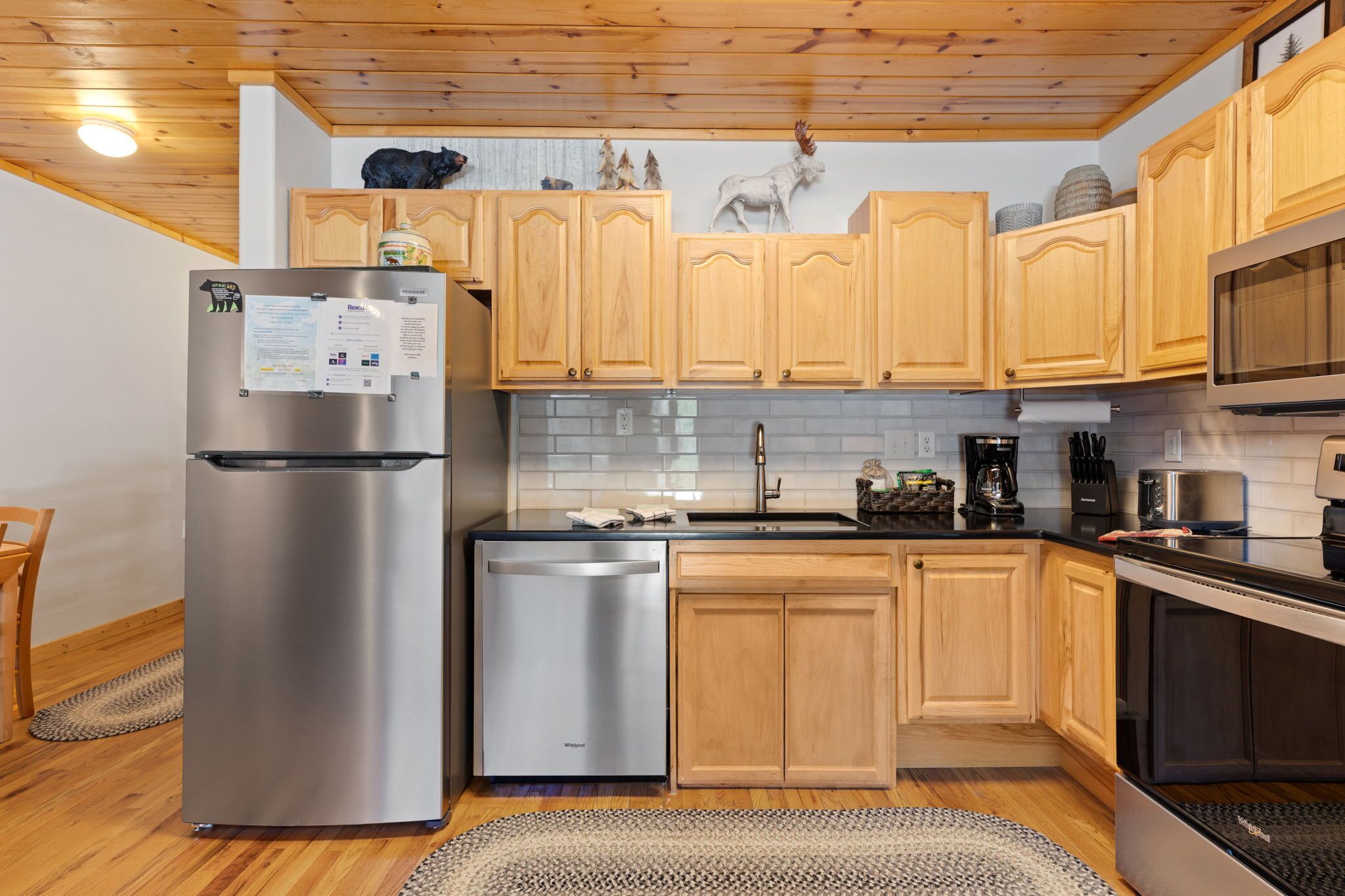 A modern kitchen with wooden cabinets, stainless steel appliances, and a built-in oven.