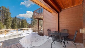 Een houten chalet met balkon, met uitzicht op een besneeerd landschap.