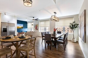 A modern kitchen with a dining area, large windows, and a cityscape view. - French Quarter Splendor: 4BR Luxury Retreat (New Orleans)
