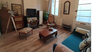 Un saló amb terra de fusta, un sofà, una taula de centre, una televisió i una llar de foc.