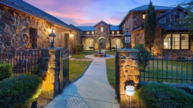 A stone house with a central courtyard, a gated entrance, and a well-maintained lawn. - Luxe Tuscan Villa on 1 Acre with Pool & Pickleball, Sleeps 18, 9 mins to DT (Sunset Valley)