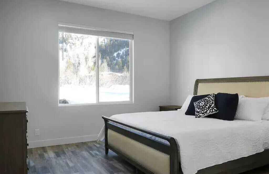 Un dormitorio con cama, ventana y cómoda.