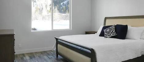 Un dormitorio con cama, ventana y cómoda.