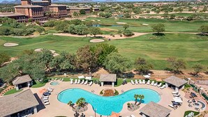 A golf course with a swimming pool and lounge area.