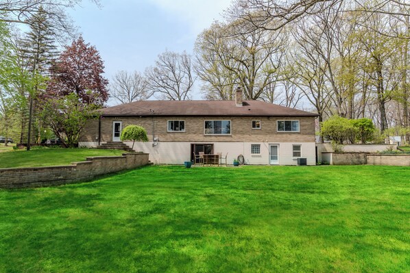 A two-story house with a brick facade, a front porch, and a well-maintained lawn.