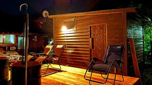 A wooden cabin with a wooden deck, two chairs, a table, a sink, and a satellite dish. - Entire old house rental, complete rental, private sauna (Saga)