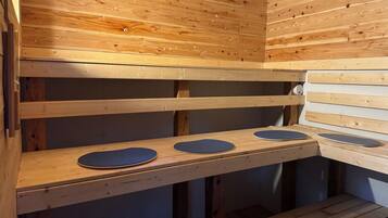 Eine Sauna mit Holzbänken und blauen Matten.