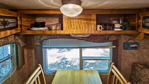 Una cucina compatta con mobili in legno, una finestra vista panoramica e un tavolo con sedie.