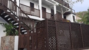 Un edificio de varios pisos con una escalera de piedra que conduce a un balcón de madera.