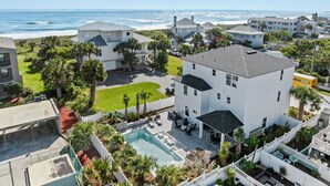 A coastal residential area with a swimming pool, multiple houses, and a view of the ocean. - The Twin Palms at Vilano Beach,  Private Pool - Steps From Beach - Minutes from everything (Vilano Beach)