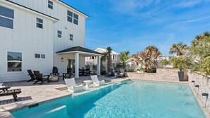 A swimming pool with lounge chairs and a patio area. - The Twin Palms at Vilano Beach,  Private Pool - Steps From Beach - Minutes from everything (Vilano Beach)
