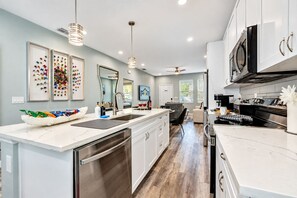 Een moderne keuken met een groot eiland, roestvrijstalen apparatuur en een eetgedeelte met uitzicht.