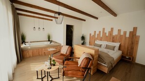 A modern room with a wooden ceiling, a bed, a sofa, a small table, and a bathroom with a bathtub. - Zemunice Kneževic  (Banja Luka)