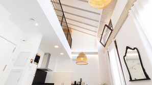 A modern kitchen with white cabinetry, a black countertop, and a hanging woven light fixture. - Ca Celieta Beach IV. WiFi+Aire Acondicionado (Valencia / València)