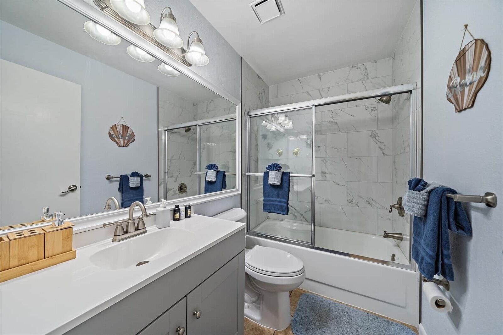 Een moderne badkamer met een wit wastafelmeubel, toilet en douchecabine.