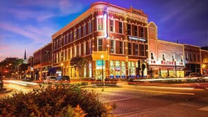 Un edificio histórico con varias fachadas comerciales, incluyendo un cartel que dice 'The Waltons'.