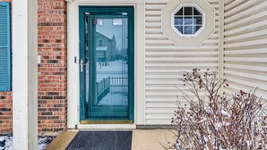 A house with a green door, a brick wall, and a window with a hexagonal frame. - Indianapolis Home w/ Private Yard ~ 8 Mi to Dtwn! (Indianapolis)