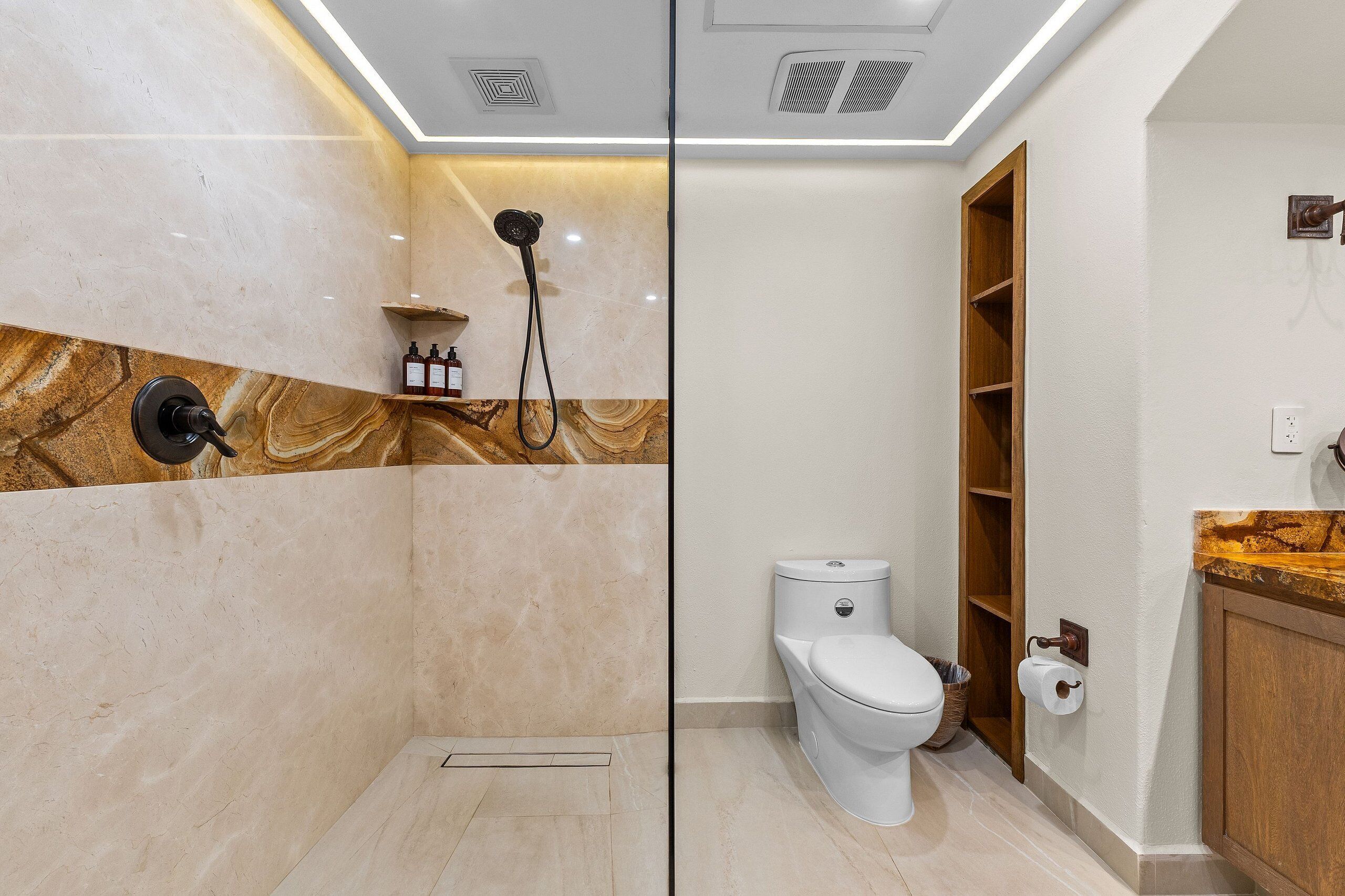 Ein modernes Badezimmer mit Dusche, Toilette und Waschtisch.