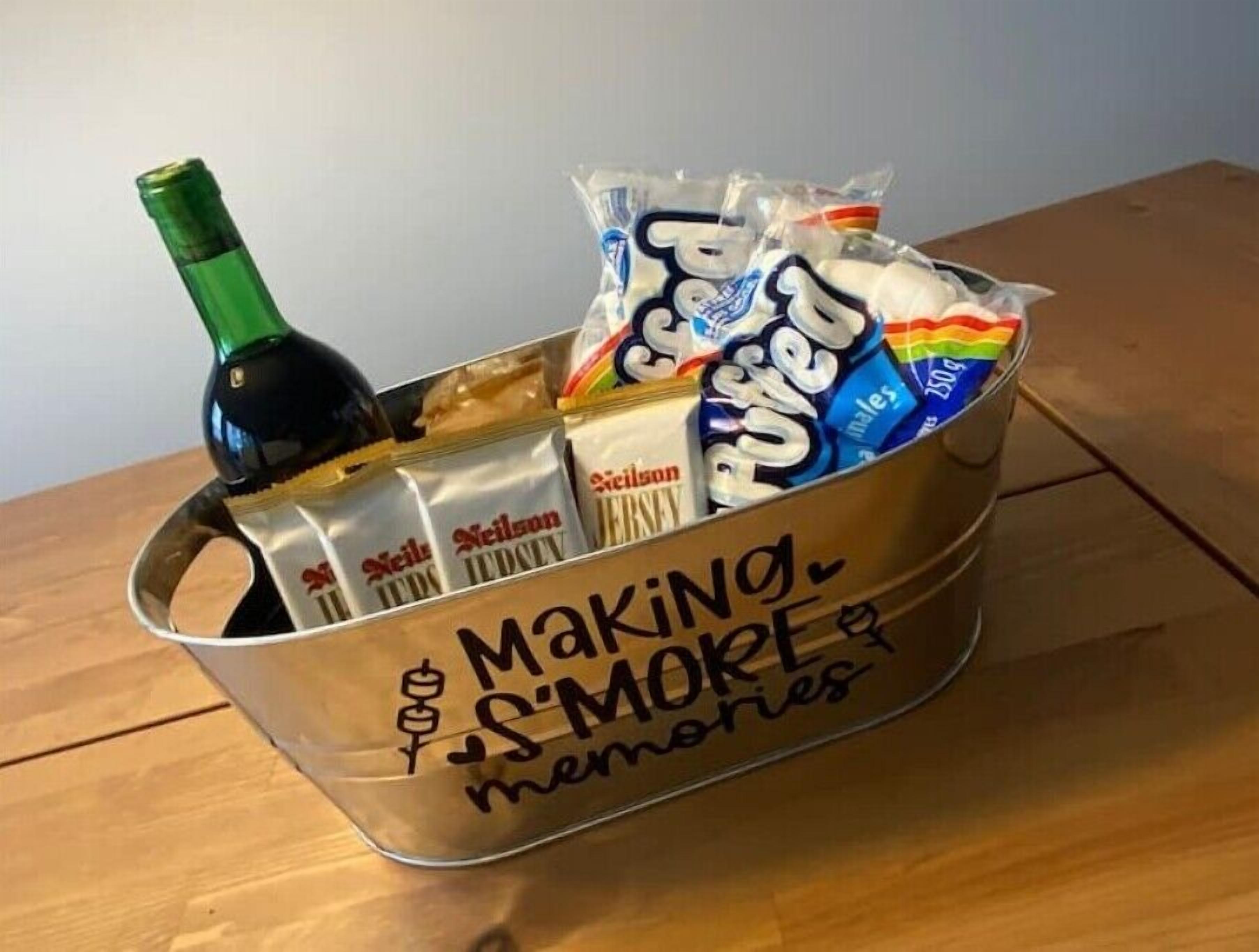 A metal bucket filled with various snacks and a bottle of wine, labeled "Making S'mores Memories."