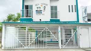 Un bâtiment sur lequel on peut lire l’inscription « Sea Horse Hostel » et dont l’entrée est fermée par un portail.