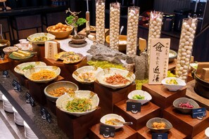 Un buffet proposant divers plats et agrémenté d’un élément décoratif central.