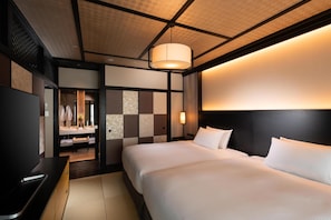 A hotel room with a bed, a TV, a desk, and a bathroom visible through an open door. - Doubletree by Hilton Kyoto Station (Kyoto)