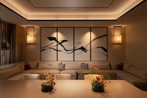 Una sala de estar moderna con un sofá, una mesa de centro y dos mesitas laterales decoradas con arreglos florales.