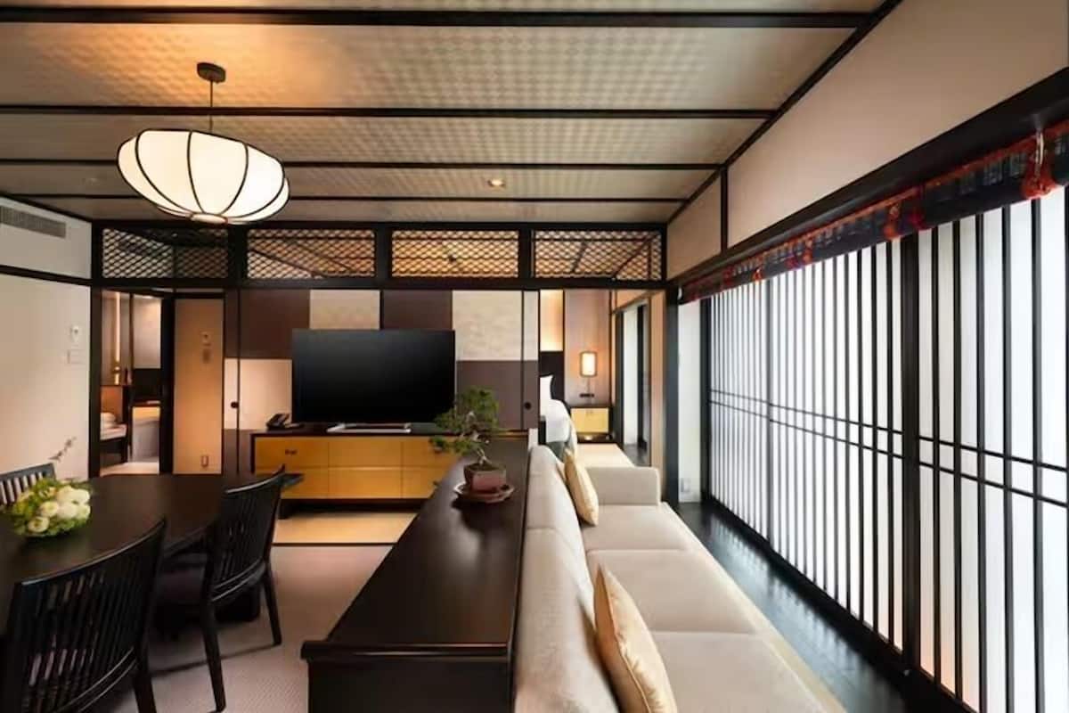 A modern living room with a sofa, TV, and dining area.