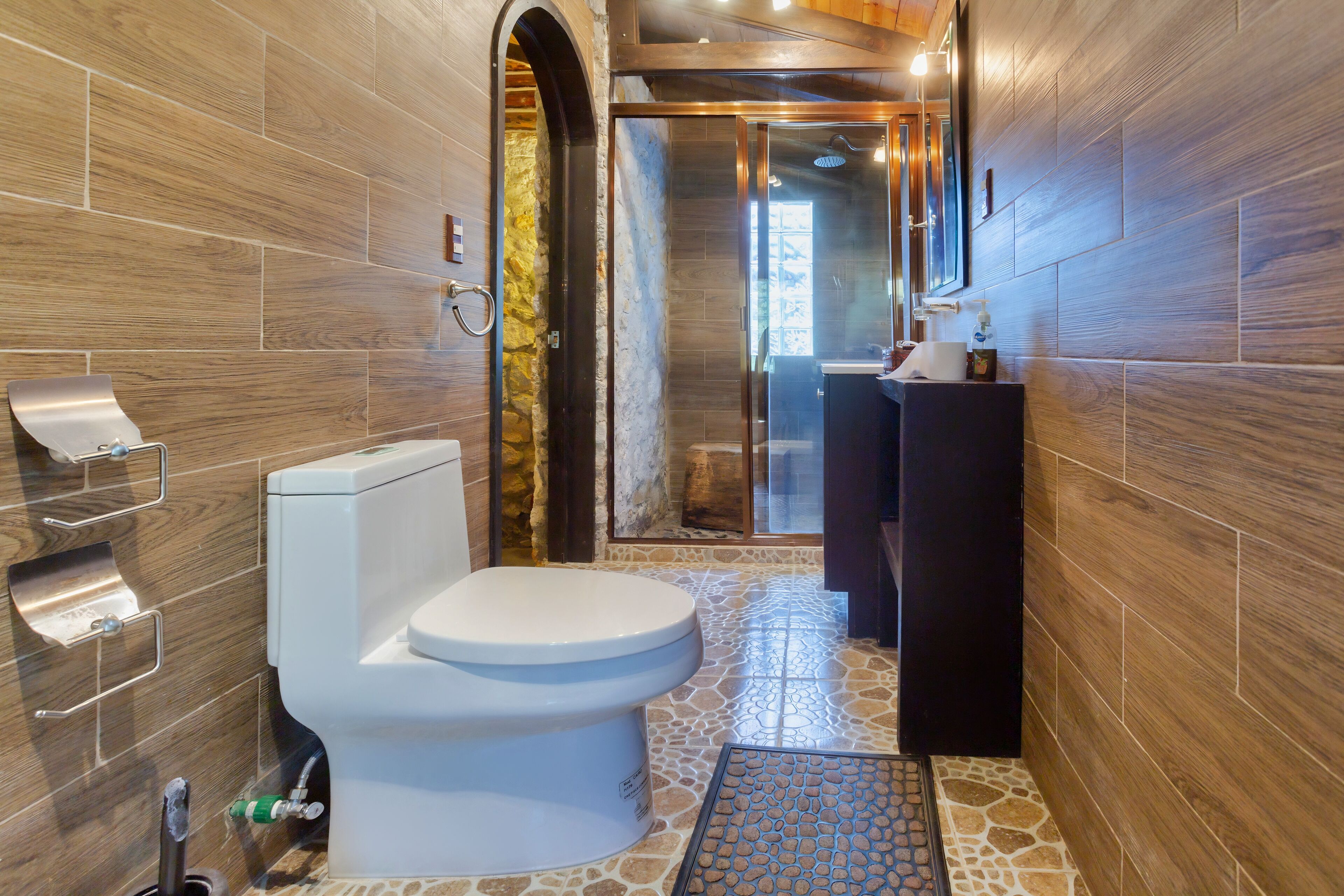 A modern bathroom with a toilet, sink, and shower area.