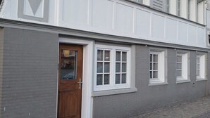 A two-story building with a grey facade and white trim. - Gemütliche Ferienwohnung in Bühler (Bühler)