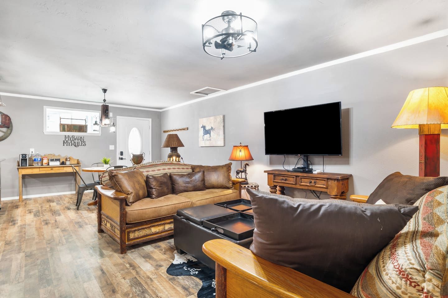 A living room with a sofa, coffee table, TV, and a dining area with a table and chairs.