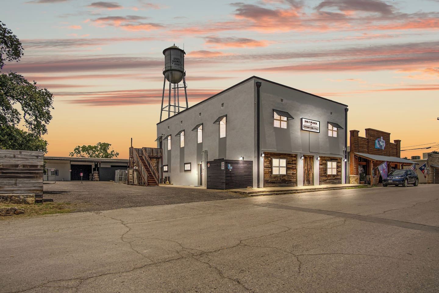 A building with a sign reading 'Salt Block Texas Salt Co.' and a water tower in the background.