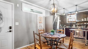 Un'area pranzo con un tavolo rotondo, sedie in legno e un lampadario.