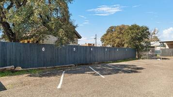 A parking lot with numbered parking spaces and a fence with numbers.