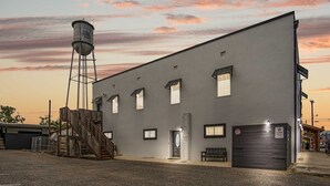 Een groot industrieel gebouw met een watertoren, een trap en een deur.