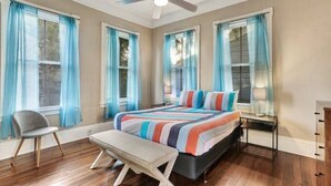 Une chambre à coucher avec un lit, un banc, une chaise et une table de chevet.