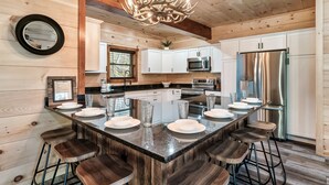 Una cocina moderna con una isla central, electrodomésticos de acero inoxidable y armarios de madera.